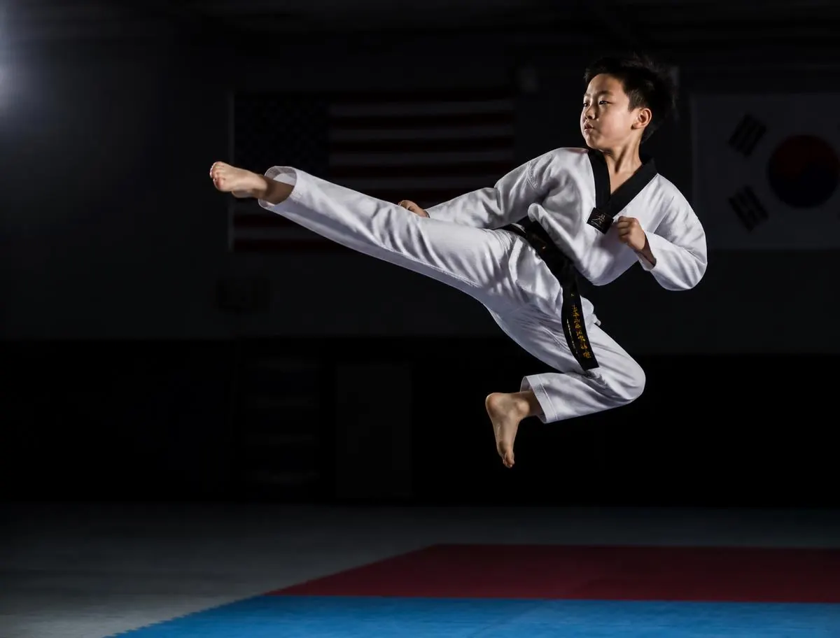 Young taekwondo student performing a jumping side kick